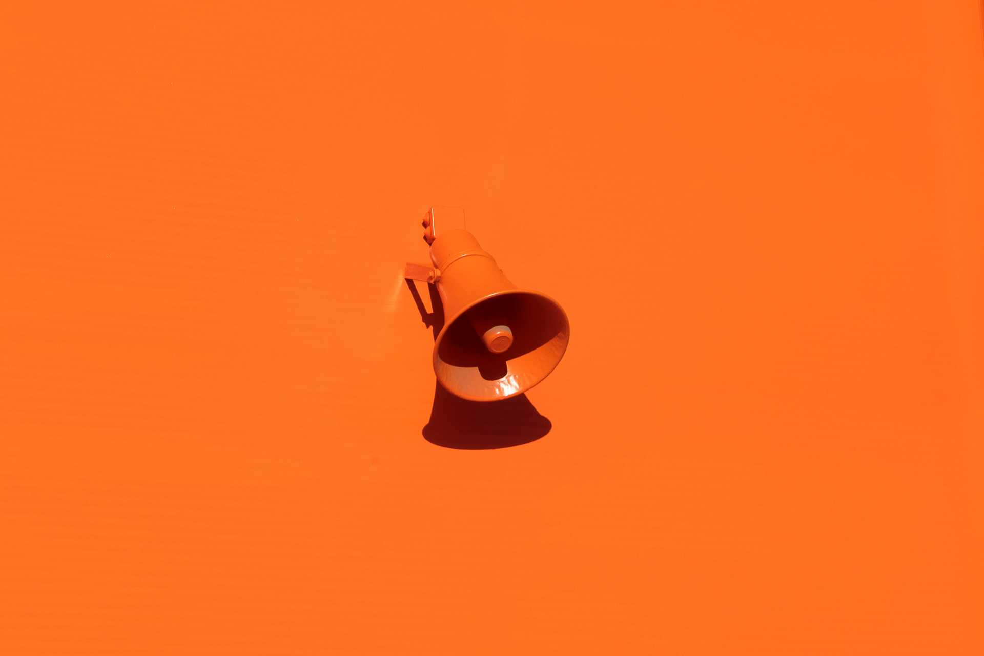 afbeelding: oranje megafoon op oranje achtergrond